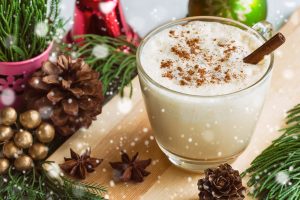 Eggnog on wooden plate with festive background
